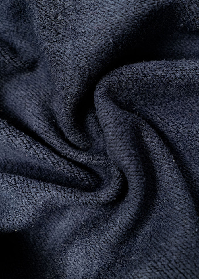 Close-up of dark, textured fabric with a soft, twisted pattern, showcasing its intricate weave and cozy appearance.