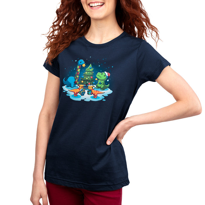 Premium Cotton T-shirt_TeeTurtle navy blue A Very Dino Christmas featuring dinosaurs celebrating around a decorated Christmas tree with snow on the ground and dinosaurs holding presents.