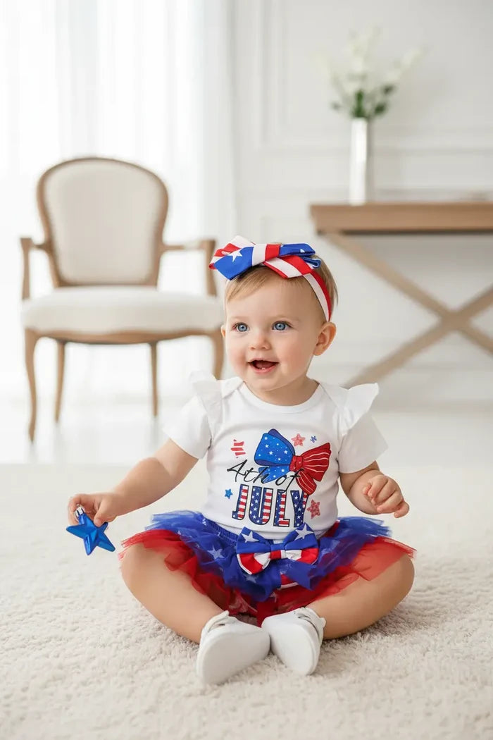 Baby wearing a patriotic outfit with a headband and tutu, sitting on a light-colored floor.