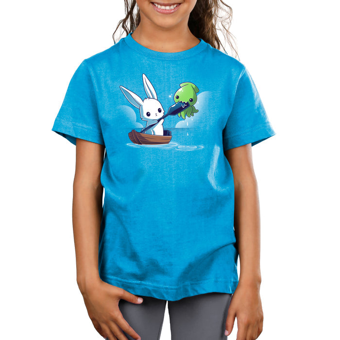 Premium Cotton T-shirt_TeeTurtle cobalt blue Baby Kraken Attack apparel featuring a baby kraken chomping on an oar being held by a bunny in a boat.