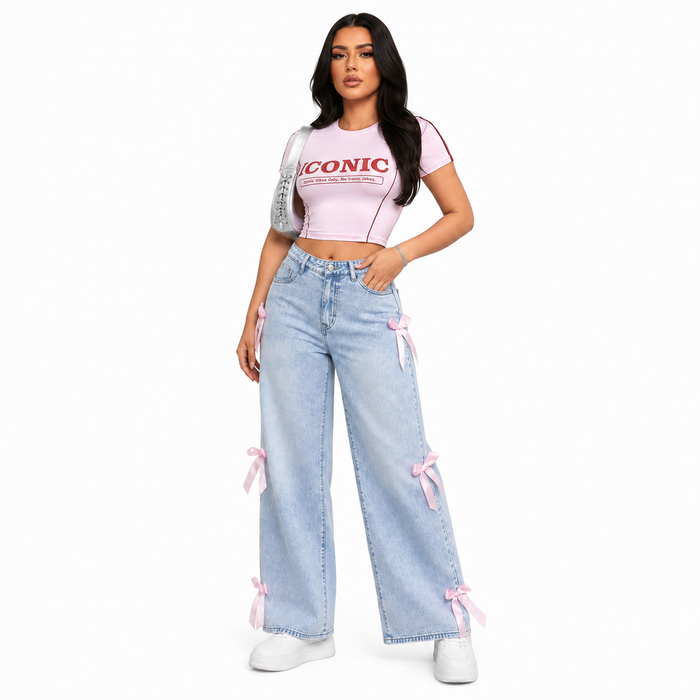 Light blue bowknot jeans for women with pink ribbon accents in a clean three-quarter studio fashion view