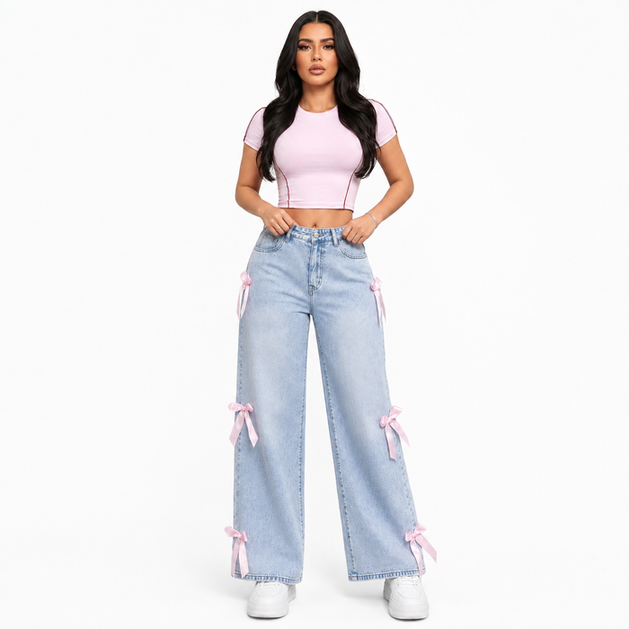 Women's light blue washed bowknot jeans with loose straight legs and pink ribbon details, front studio product view