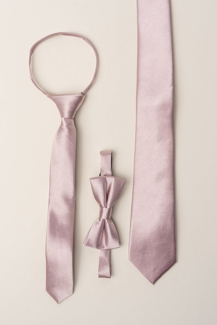 Displayed side by side on a neutral background, the Ivy City Co Boys Max Tie in Blush, along with a coordinating pre-tied boys tie and blush satin bow tie, offer a refined touch for any formal occasion. This elegant set is perfect as wedding accessories, seamlessly blending style and sophistication.