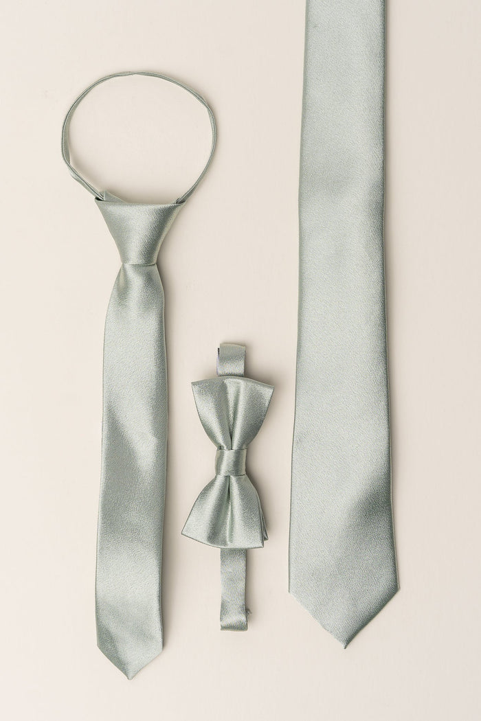 Three light silver ties from Ivy City Co’s Boys Max Tie in Sage collection are displayed vertically: a zipper tie on the left, a clip-on bow tie—ideal for boys attending formal occasions—in the center, and a classic necktie on the right, all set against a simple light background. An elegant wedding accessory set perfect for any special event.