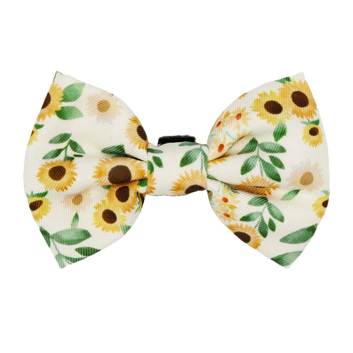 The Sassy Woof Cat Bowtie - Sunflower Dreams features a white base with yellow sunflowers and green leaves, perfect for your cat’s collar or matching harness—a cute accessory for any sunflower-loving pet.
