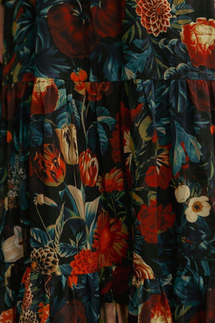 Close-up of the Ivy City Co Cordelia Dress in Moody Floral—chiffon with a vibrant floral pattern of red, orange, white, and yellow blooms on a dark backdrop. Soft folds and gatherings make it fall-ready and maternity friendly.