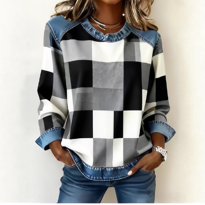 Person wearing a checkered shirt with denim trim on a plain background
