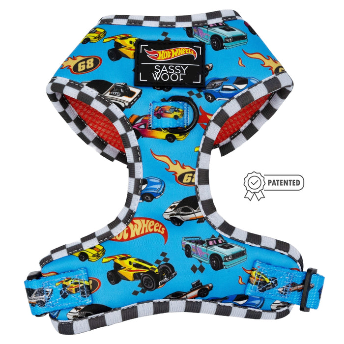 The Dog Adjustable Harness - Hot Wheels™ by Sassy Woof features blue fabric, black-and-white checkered trim, orange mesh lining, a "Patented" badge, adjustable fit for growing pups, and the "Sassy Woof" label.