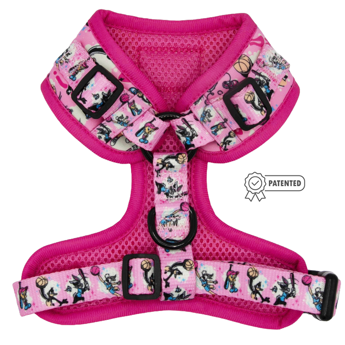 The Sassy Woof Dog Adjustable Harness - Looney Tunes™ Pink features black buckles and rings, a playful cartoon dog and ball design, and a Patented label—ideal for puppy growth and comfort.