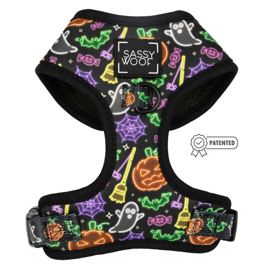 The Sassy Woof Dog Adjustable Harness – Neon Frights features neon Halloween designs with ghosts, pumpkins, and bats. It offers comfort, a patented icon, and a signature front label—perfect for your pup’s spooky festivities.