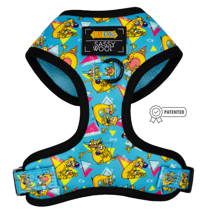 The Sassy Woof Dog Adjustable Harness – Nickelodeon CatDog™ features a vibrant cartoon pattern, black trim, adjustable straps, and a “Patented” badge—ideal as a no-pull harness for fashion-forward pups.