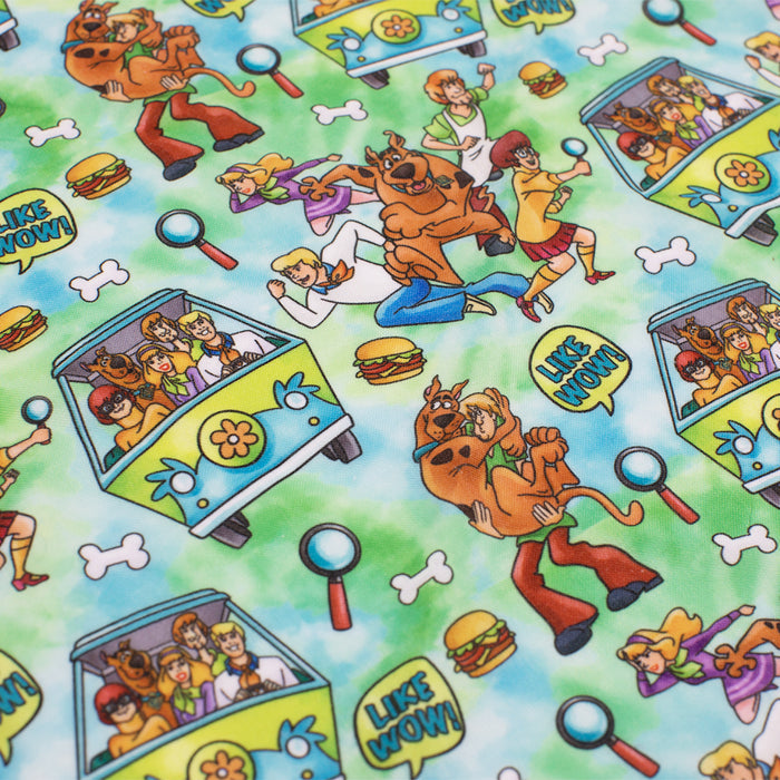 The Dog Bandana - Scooby-Doo™ by Sassy Woof features a colorful pattern with Scooby-Doo characters, the Mystery Machine, hamburgers, dog collars, bones, magnifying glasses, and LIKE WOW text on a blue and green background.