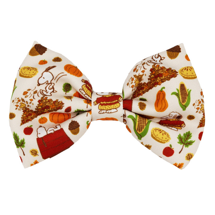 The Sassy Woof Dog Bowtie – Peanuts™ Harvest features cream fabric with autumn-themed Snoopy, pumpkin pie, corn, leaves, pumpkins, and a festive feast from the Peanuts Collection—perfect for Thanksgiving style.