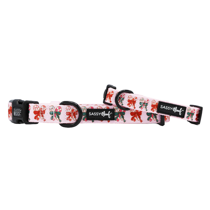 Two Dog Collar - Candy Cane Coquette accessories by Sassy Woof: pink, adjustable, with festive red, green & white candy cane bows. Both feature black plastic buckles, rings, and a black Sassy Woof label.