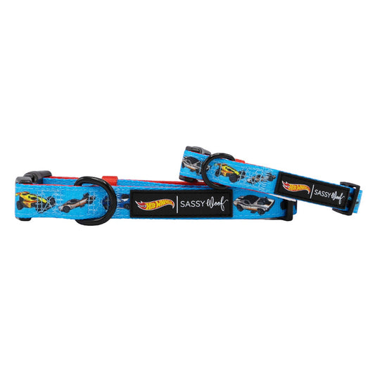 Two blue Sassy Woof Dog Collar - Hot Wheels™ adjustable collars with black plastic buckles and rings, each featuring the Sassy Woof label, are overlapped on a white background for a stylish and comfortable look.