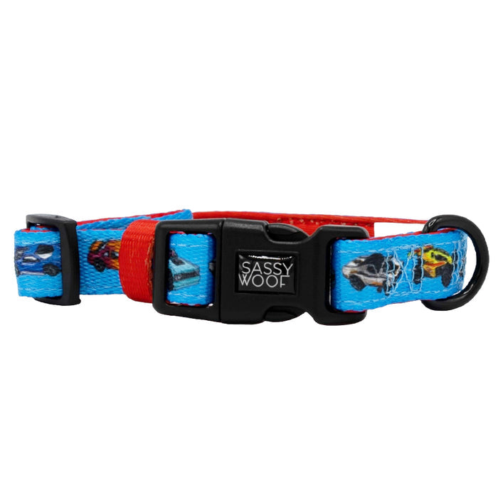 The Sassy Woof Dog Collar - Hot Wheels™ features colorful cars in blue and red, a black plastic buckle, and D-ring. Adjustable for comfort, it includes the Sassy Woof brand tag—perfect for stylish pups!.