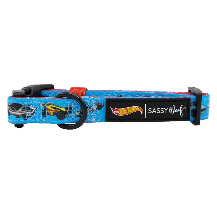 The Sassy Woof Dog Collar - Hot Wheels™ is a blue adjustable collar with a fun car design, black plastic buckle, D-ring, and Hot Wheels and Sassy Woof logos—ideal for pups on the Puppy Growth Pawtection Plan.