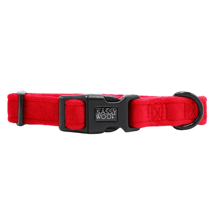 The Sassy Woof Dog Collar - Naughty features a bright red design with a black plastic buckle, black D-ring, and stitched label. This adjustable holiday collar pops against any background—ideal for adding festive cheer to your dog's look.