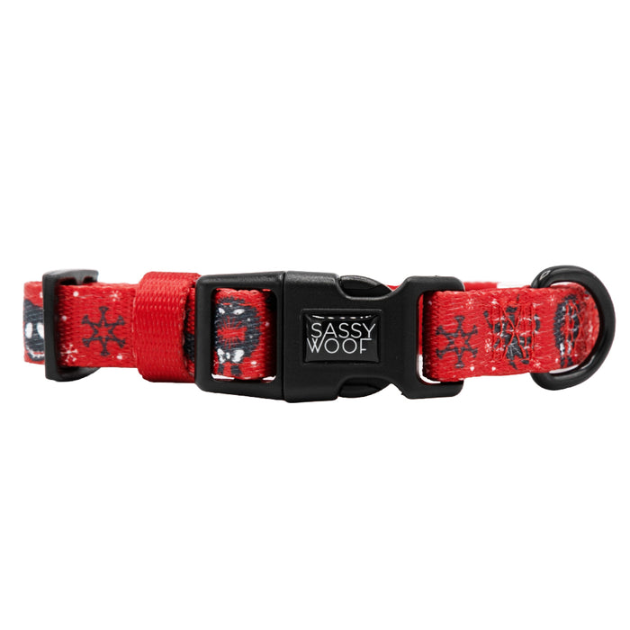 The Sassy Woof Dog Collar - The Nightmare Before Christmas™ (Red) features an adjustable fit, black plastic hardware, and small black-and-white cartoon designs inspired by the movie, with the brand name on the buckle.
