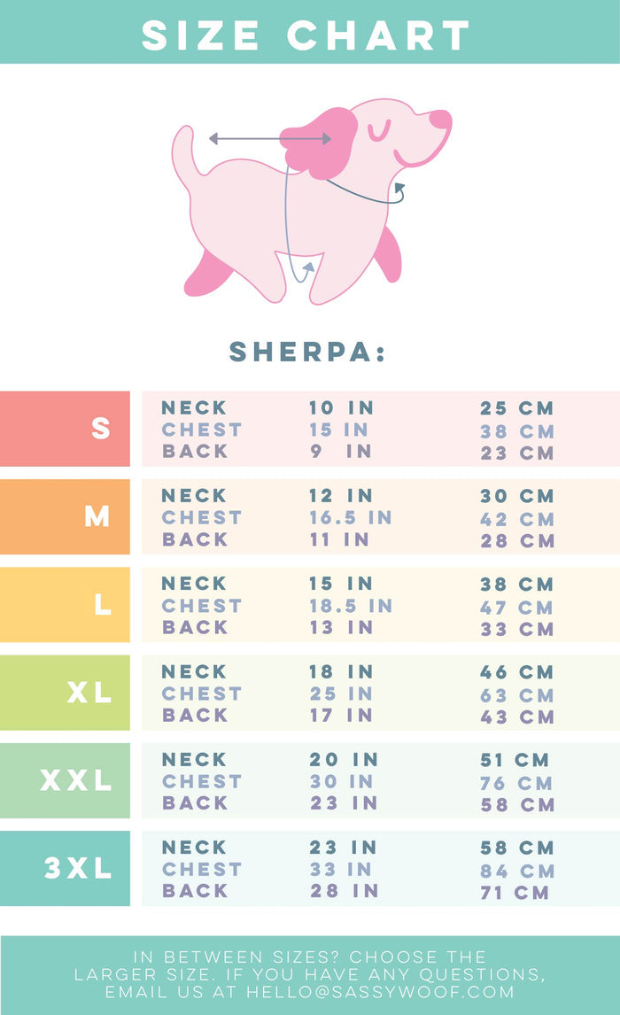 A vibrant size chart for the Sassy Woof Dog Reversible Sherpa Jacket - Deck the Paws displays a pink dog illustration with neck, chest, and back measurements (inches/cm) for sizes S to 3XL—perfect for finding your pup's fit.