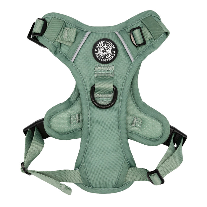 The Sassy Woof Dog Step-in Harness - Sage is a reflective, adjustable harness with black buckles, a central D-ring, and a circular “Sassy Woof, Tails on Trails” chest patch.