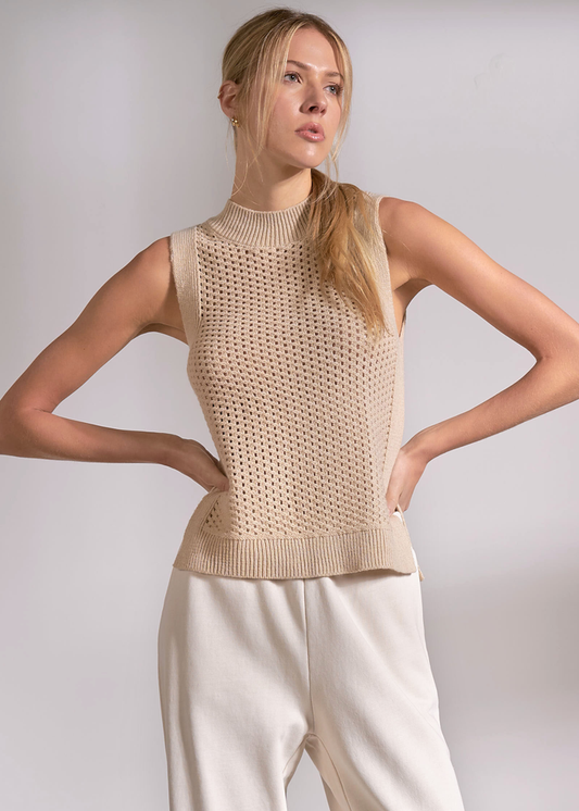 Woman wearing a tan knit tank top with cream pants