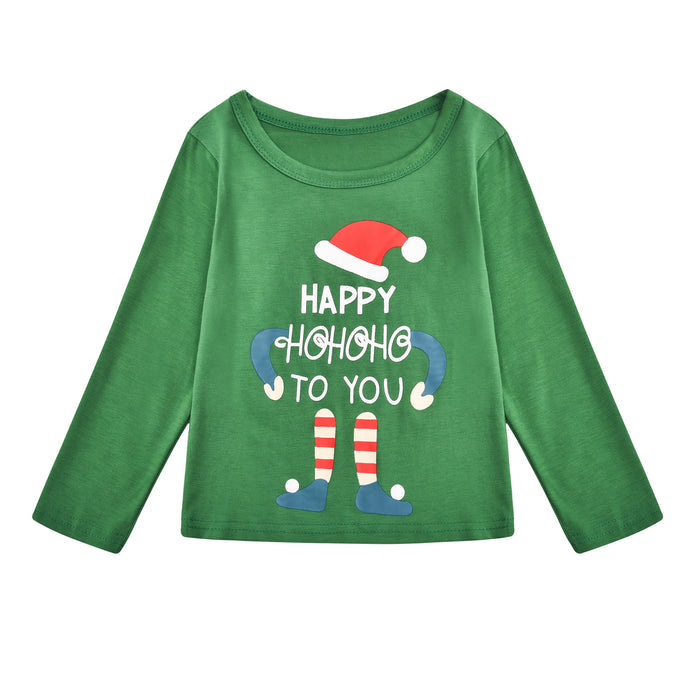 Parents and children in green Christmas pajamas decorating a holiday tree