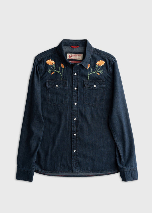Denim shirt with floral embroidery on shoulders, featuring two chest pockets and button closure, displayed on a plain background.