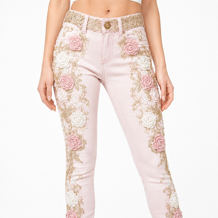 Close-up of pink floral embroidered jeans with raised rose appliques, gold vines, waistband and stitching
