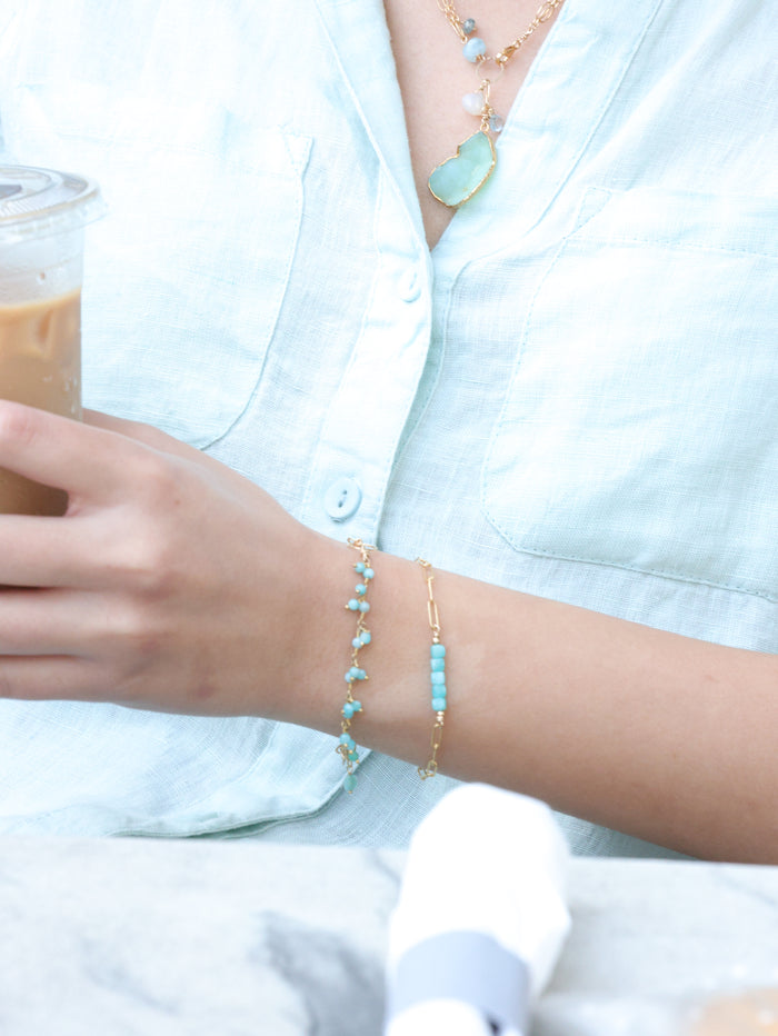 close up of amazonite tiny stone bracelets layered on model