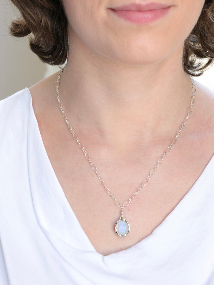 Georgina nh Necklace in Moonstone on model. Styled with white silk v neck top