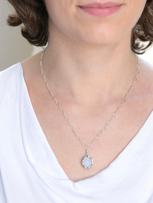 Georgina nh Necklace in Moonstone on model. Styled with white silk v neck top