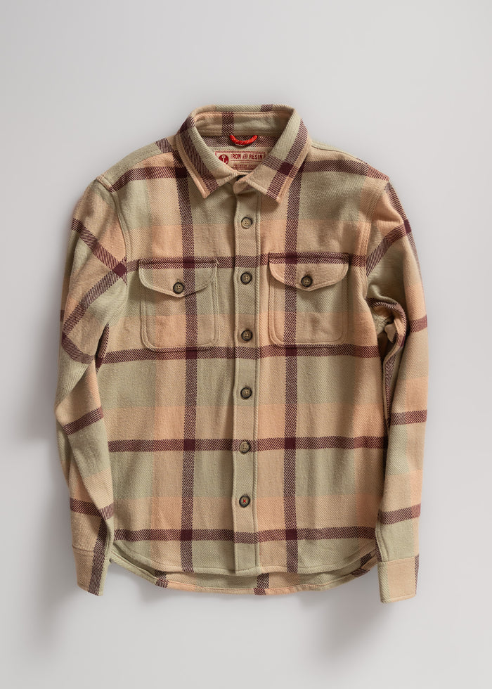 Beige and burgundy plaid flannel shirt with buttoned chest pockets, laid flat on a light surface, showcasing its classic design.