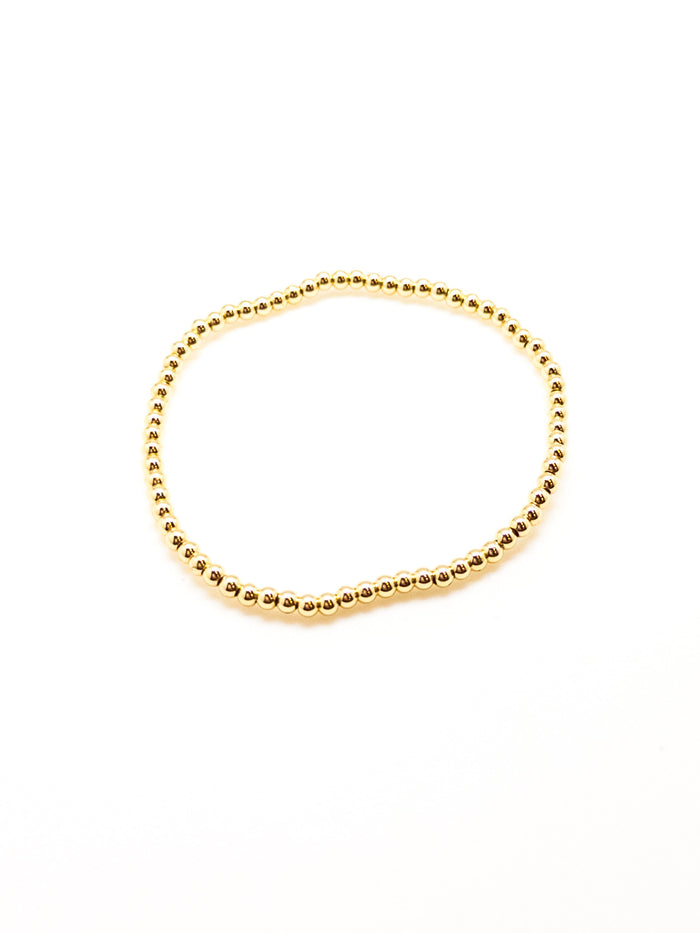 A gold-filled bracelet with a sleek, beaded design, displayed against a white background.