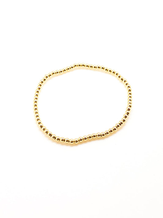 A gold-filled bracelet with a sleek, beaded design, displayed against a white background.