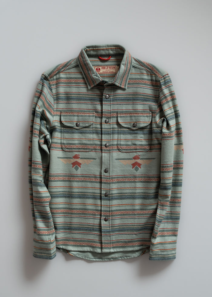 Striped button-up shirt with geometric patterns, two chest pockets, and a collar, displayed against a plain background.