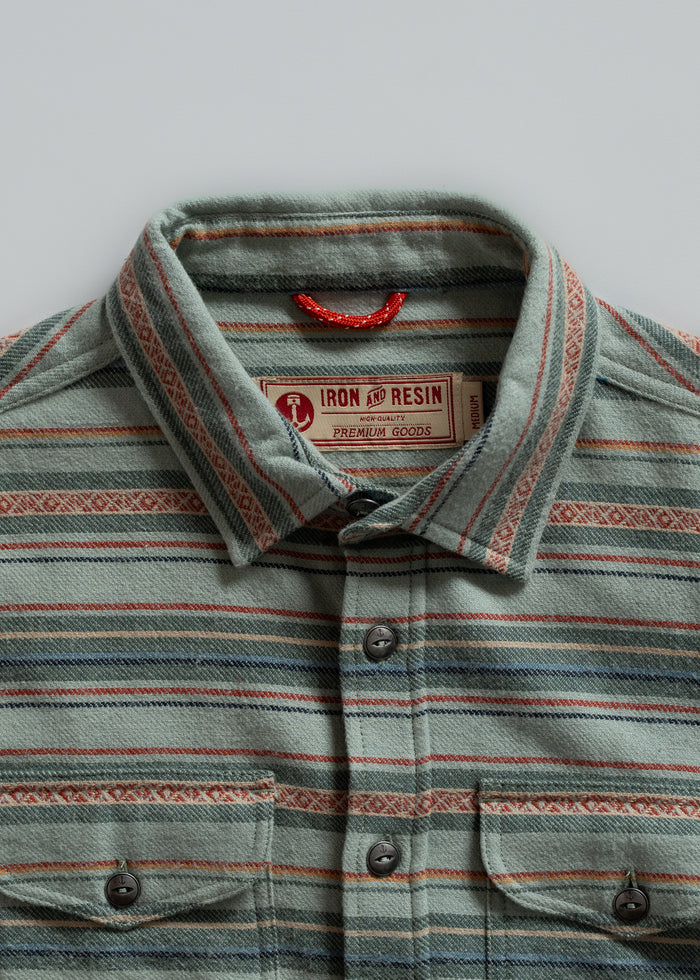 Striped button-up shirt with a red loop, featuring Iron and Resin label. Earthy tones and patterns create a vintage look.