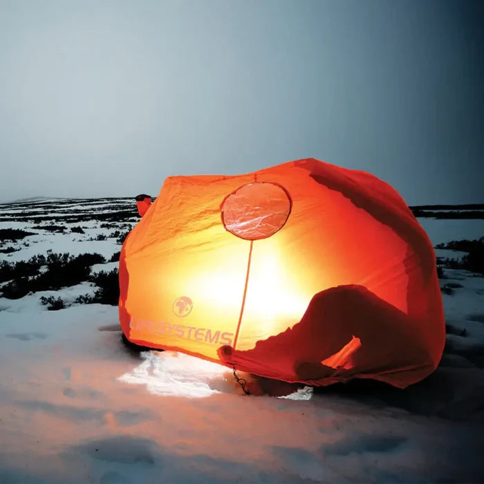Lifesystems Survival Shelter 2 Man being used in the snow at dusk with a light illuminating the inside
