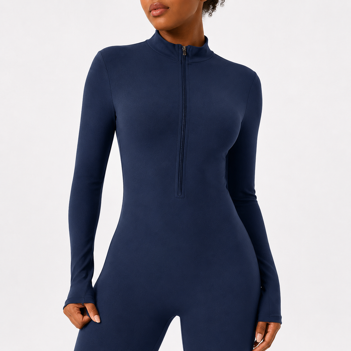Long sleeve workout jumpsuit in Navy Blue with a close-up view of the half zip front, mock neck and fitted activewear design.