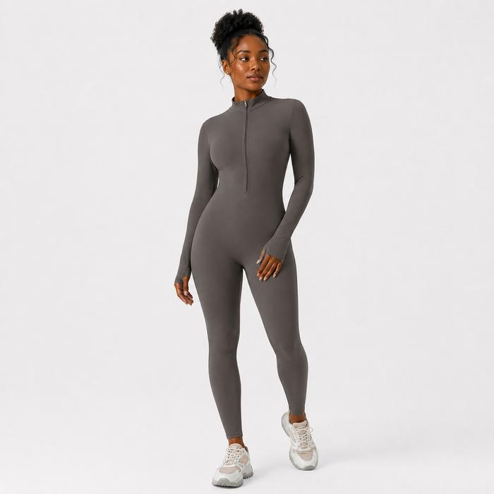 Charcoal Gray athletic jumpsuit in a relaxed full-length angle with half zip styling, mock neck and a fitted one-piece shape.
