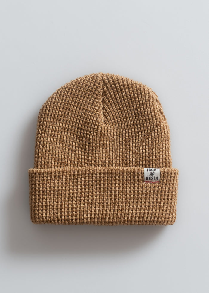 Tan waffle-knit beanie with a folded brim and an "Iron and Resin" label, set against a plain white background.