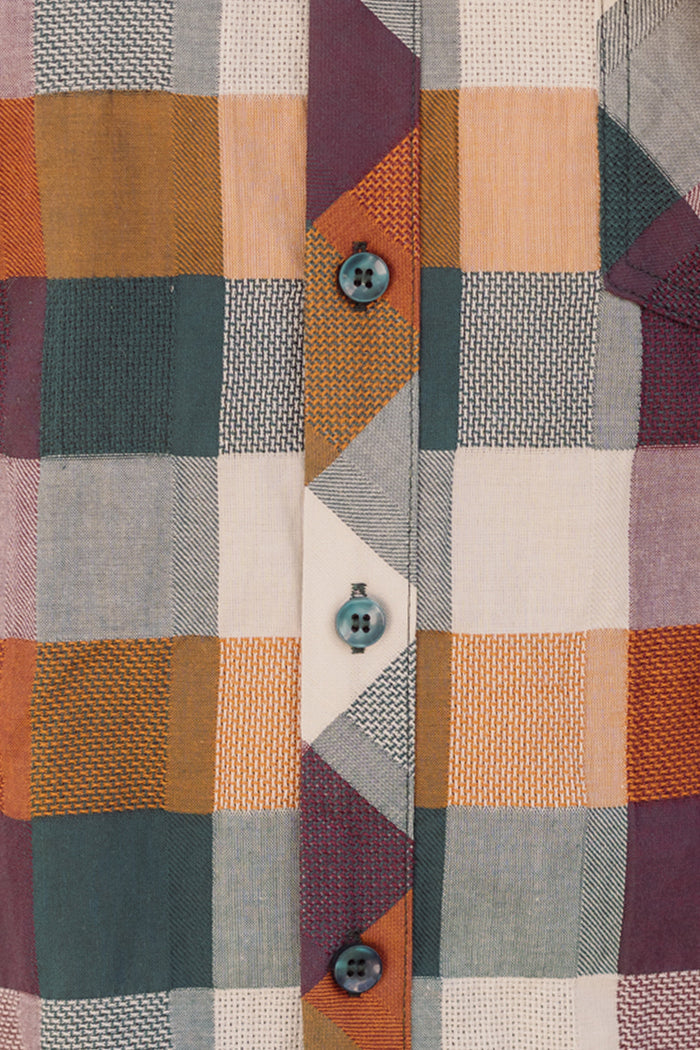 Close-up of the Mens James Shirt in Maize Gingham by Ivy City Co, crafted from a cotton-blend with a gingham pattern in orange, green, cream, and purple. This shirt features three blue buttons down the center and a classic collar neckline.