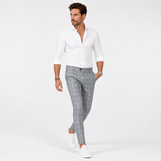 Light grey plaid trousers on an adult male model walking in a white studio to show fit, movement, and a natural fabric drape.