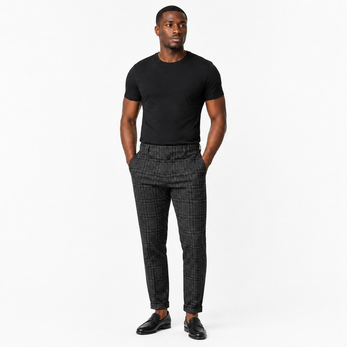 Men's black plaid pants on an adult Black male model in a clean main commercial studio pose for a Shopify main product image.