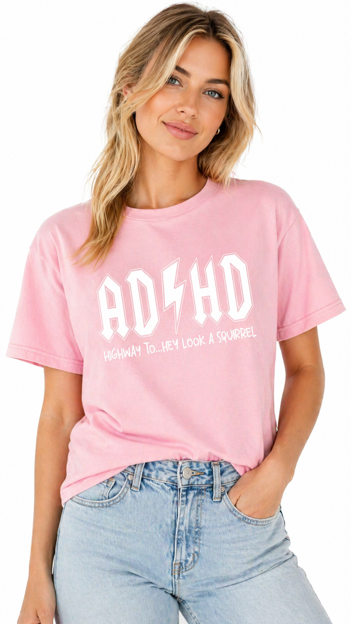 Woman wearing a pink t-shirt with 'ADHD' and a lightning bolt graphic.