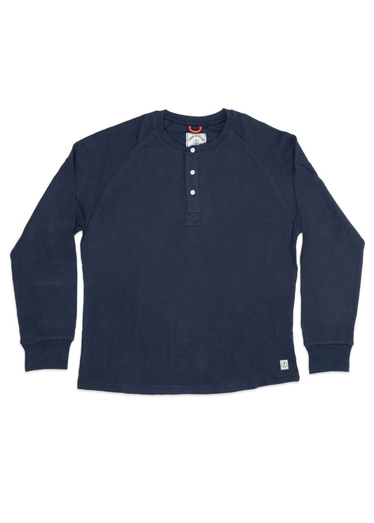 Navy blue long-sleeve henley shirt with four buttons and a small logo tag at the hem, laid flat on a white background.