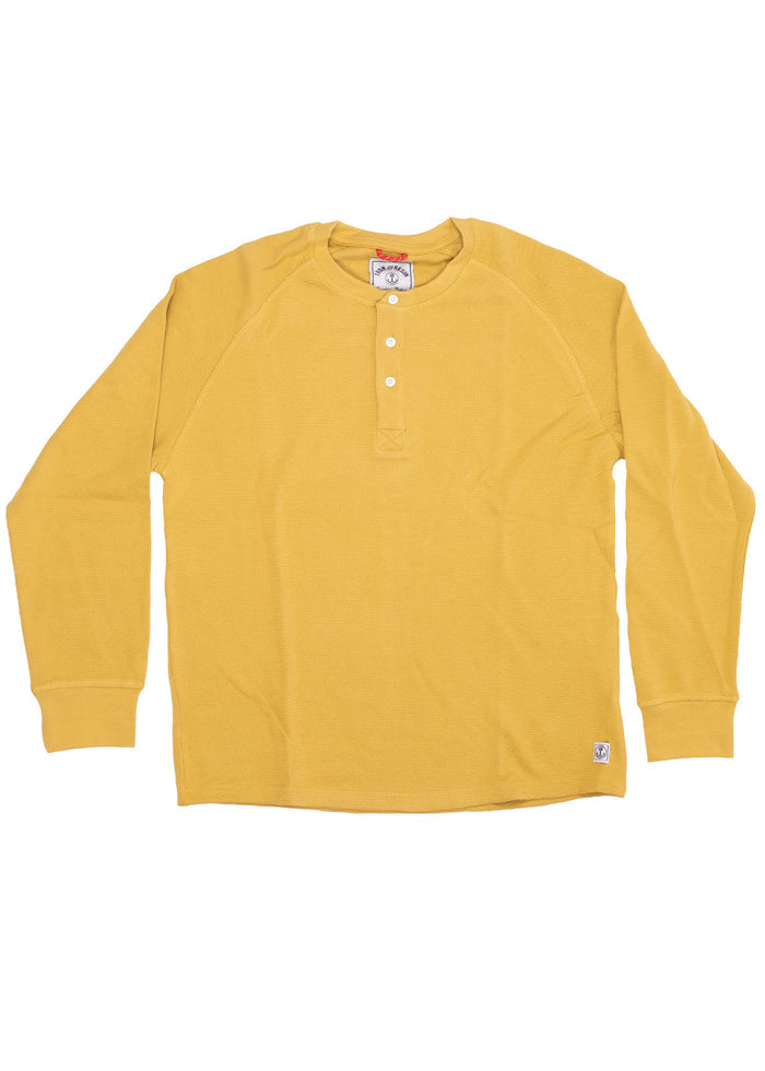 Yellow long-sleeve henley shirt with button placket, laid flat. Features ribbed cuffs and a small logo tag at the hem.
