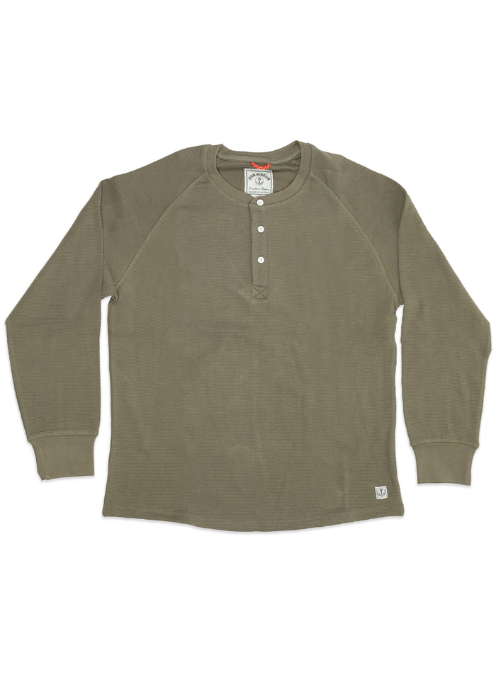 Olive green long-sleeve henley shirt with three white buttons, ribbed cuffs, and a small logo tag at the bottom left.