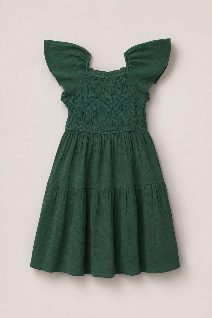 The Mini Jade Dress in Evergreen by Ivy City Co features a dark green hue, short flutter sleeves, a smocked bodice, and a tiered skirt, shown against a neutral background.