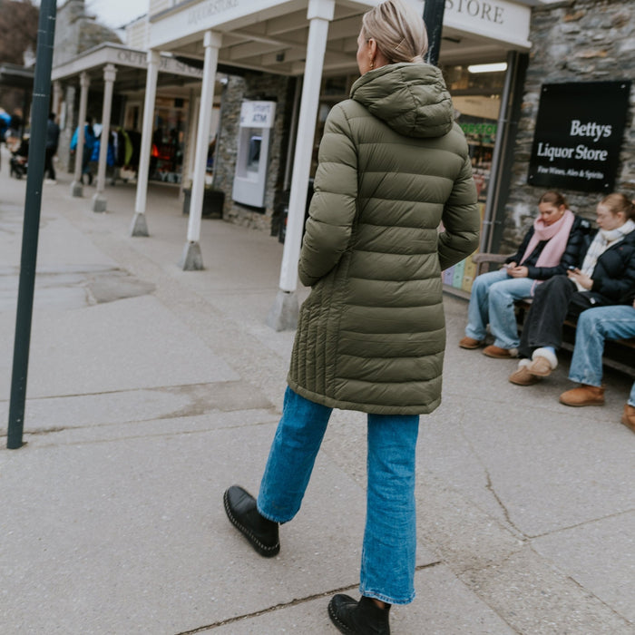 Woman wearing Moke - Sydney Cloud Touch 90/10 Down Coat (SYDNEY) in the colour Black while walking down a street.